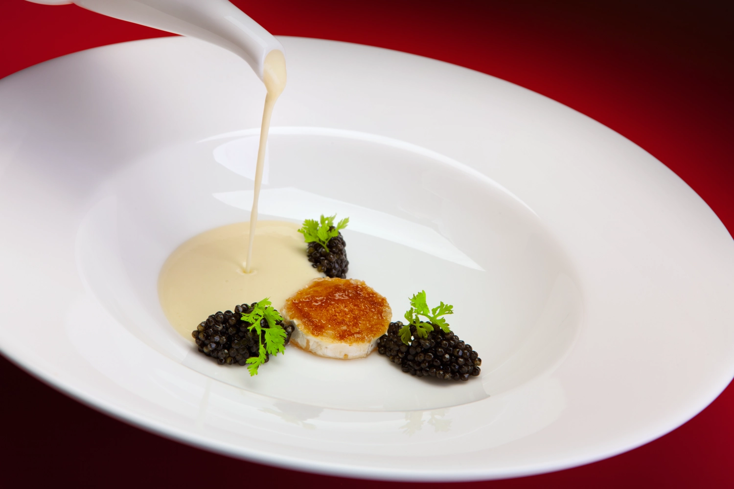 White potato soup with imperial caviar and caramelized goat cheese