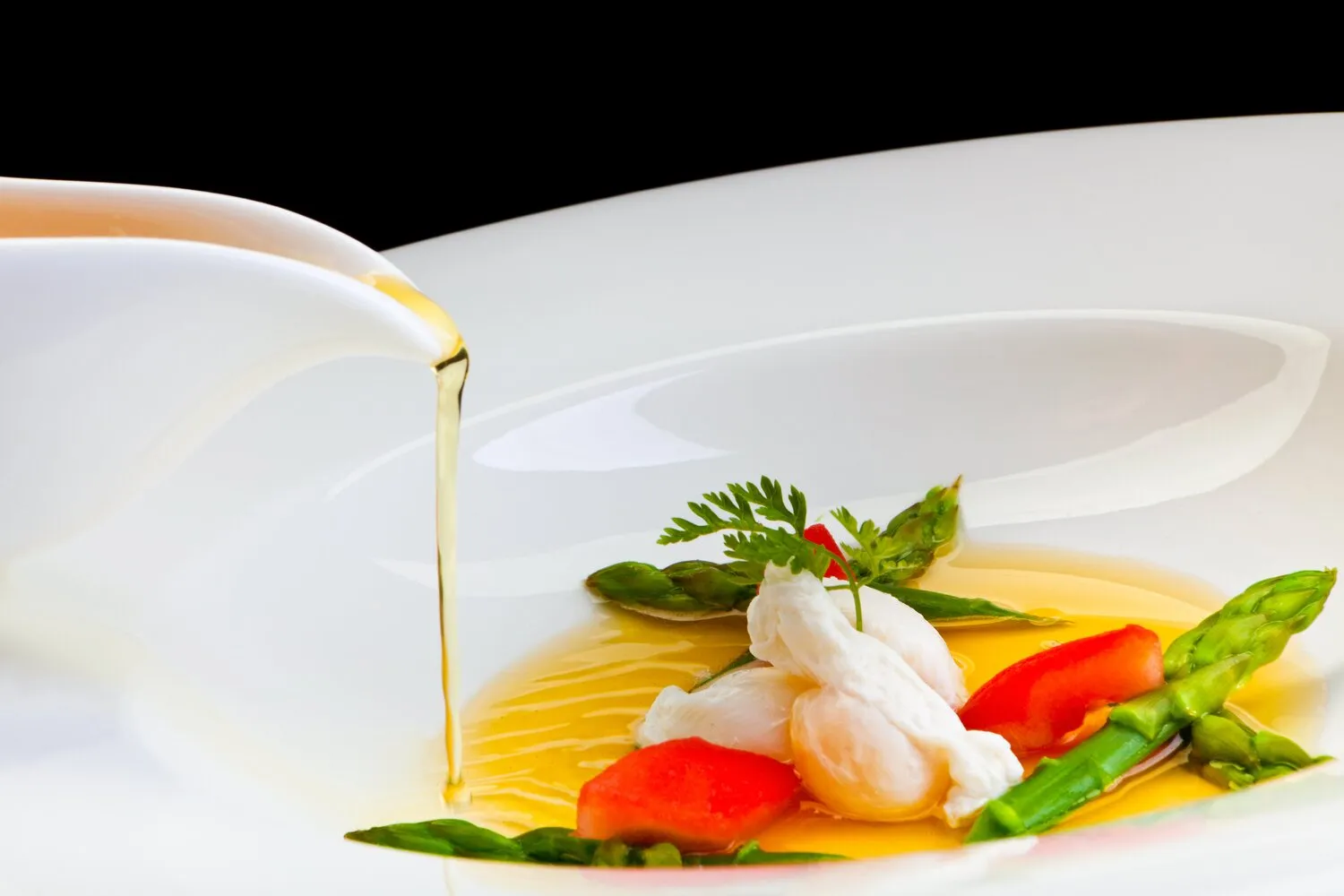 Tomato lemongrass consommé with poached quail egg and green asparagus tips